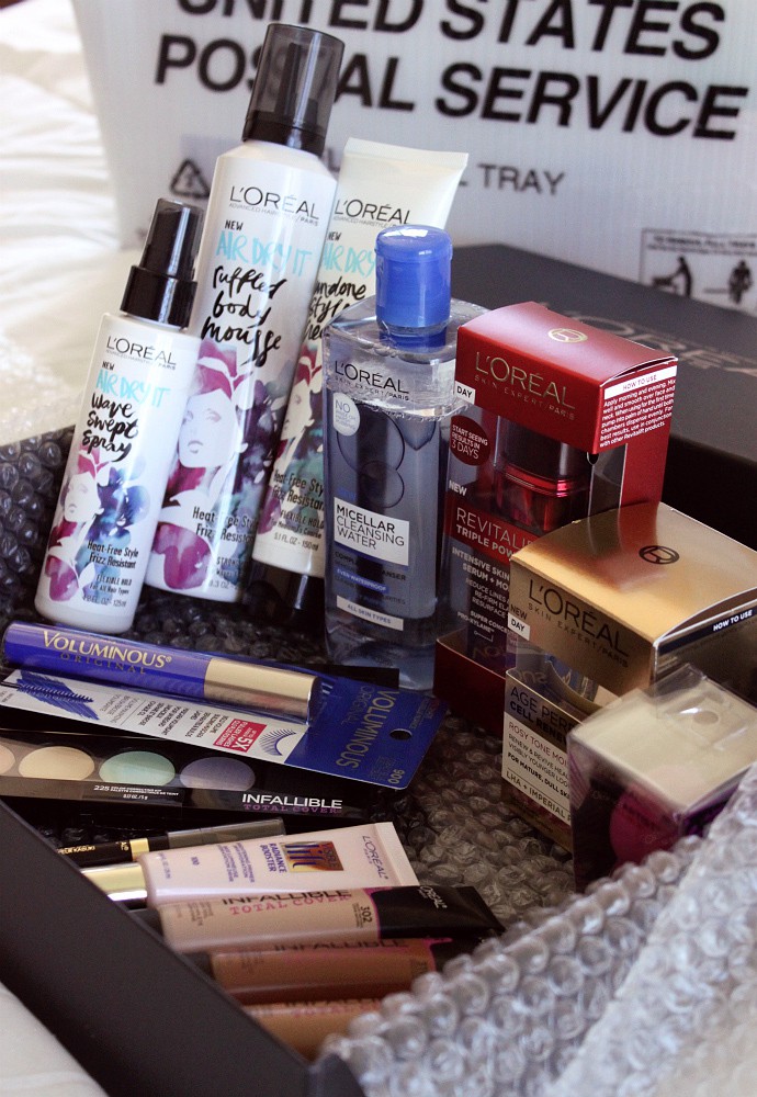 L'Oreal PR package: Air Dry It Un-Done Style Cream, Air Dry It Ruffled Body Mousse, Air Dry It Wave Swept Spray, Infallible Total Cover Foundation, Visible Lift Radiance Booster, Brow Stylist Kabuki Blender, Infallible Total Cover Concealing & Contour Kit, Infallible Total Cover Color Correcting Kit, Infallible Blend Artist Foundation Blender, L'Oreal Paris Voluminous Original Mascara Cobalt Blue, Age Perfect Cell Renewal Rosy Tone Moisturizer, Micellar Cleansing Water, and Revitalift Triple Power Moisturizer and Serum